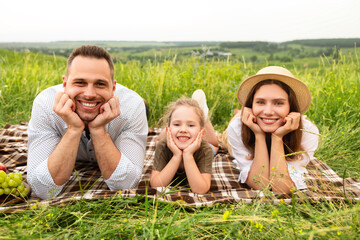 Happy lovely young family spending time together on a picnic