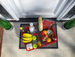 Food and eats online buying and delivery concept. Shopping basket with grocery in front of door. Top view. 3d illustration