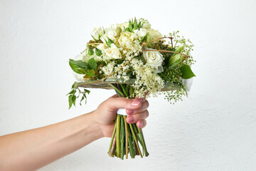 Green wedding bouquet in woman hands on white background