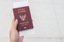 Hand Holding Thailand Passport And Boarding Pass Ticket. Travel, Vacation And Transportation Concepts