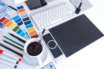 Designer Flatly. Desktop of the mobile app designer. Computer, graphic tablet, markers and color palettes on the table. Development of mobile app design.