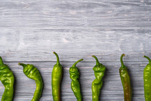 Hot Spicy Green Chili Pepper In Row, Wooden Board Background, Top View Copy Space