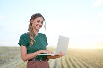 Woman farmer smart farming standing farmland smiling using laptop Female agronomist specialist research monitoring analysis data agribusiness