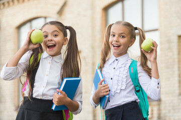 Students girls classmates with backpacks having school lunch, hungry kids concept