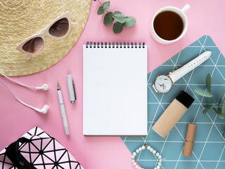 Wall Mural - Blank notepad mockup. Flat lay feminine pink desktop with a cosmetic, straw hat, tea and opened notepad. Copy space