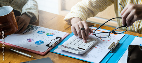 Cuadros en Lienzo Young accountant marketing team consultants and using calculator to analyze sales growth in the global workplace market
