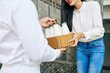 © DragonImages - Close-up image of smiling young woman receiving order of fresh milk at doors of her house