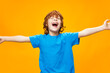 © SHOTPRIME STUDIO - happy red-haired kid in blue t-shirt throws up his hands to the sides
