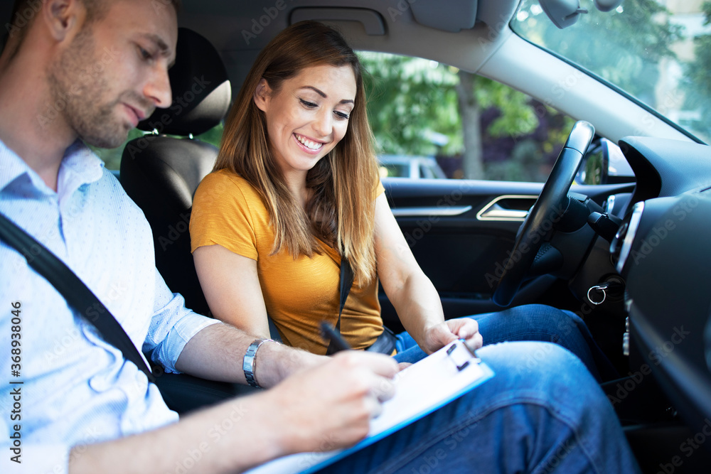 Road Lessons Taking driving lessons. Car instructor explaining city traffic rules ...