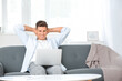 © Pixel-Shot - Young man with laptop relaxing on sofa at home