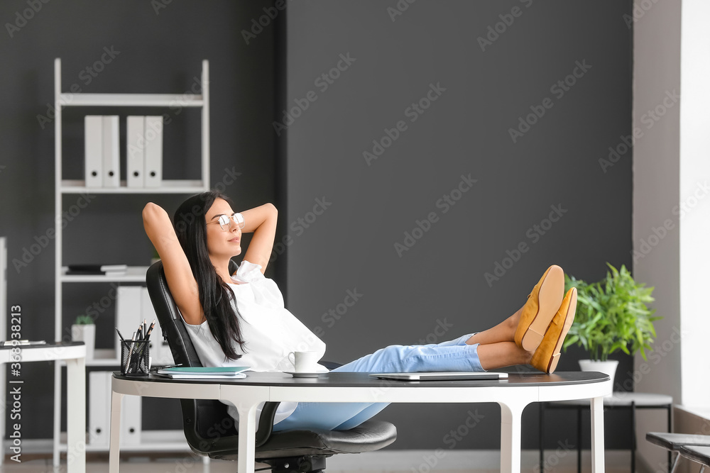 Young woman relaxing at workplace in office