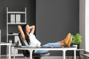 Wall Mural - Young woman relaxing at workplace in office