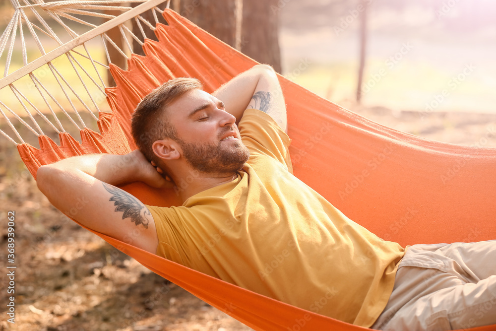 Young man relaxing in hammock outdoors