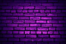 Neon Light On An Old Brick Wall. Purple Grunge Background. Lighting Effect.