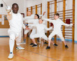 © JackF - African American man wearing fencing uniform practicing with foil at gym
