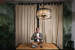 © Alexandr - Full length of a relaxed mature young hipster sitting in sunglasses on table at home