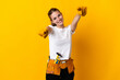 © luismolinero - Young electrician woman isolated on yellow background points finger at you while smiling