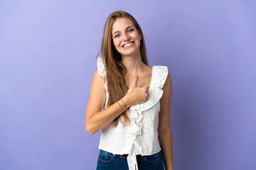 Wall Mural - Young caucasian woman over isolated background giving a thumbs up gesture