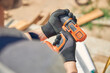 © Svitlana - Builder in cut-resistant gloves preparing for driving screws