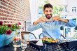 © baranq - Cheerful young businessman taking photo of breakfast in outdoors cafe