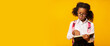 © Prostock-studio - African American Schoolgirl Learning Reading Book Over Yellow Background, Panorama
