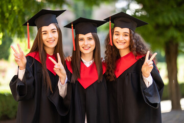 Wall Mural - Happy, young female group of university graduates at graduation ceremony