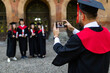 © F8  \ Suport Ukraine - Young group of graduation students take photo on the phone at campus after ceremony
