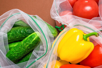 Fresh ripe and juicy vegetables in reusable eco-friendly mesh bags. Plastic free, zero waste, and sustainable living concept. Reusable using. Top view. Closeup view.