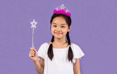 japanese girl wearing crown holding magic stick over purple background