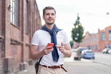 Canvas Print - Handsome smiling man listening to music while walking in the city.