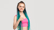 © golubovy - Woman with blue braids. Like sign. Portrait of cheerful lady in pink top with colorful hair showing thumb up isolated on white copy space. Beauty salon. Creative ethnic hairstyle.