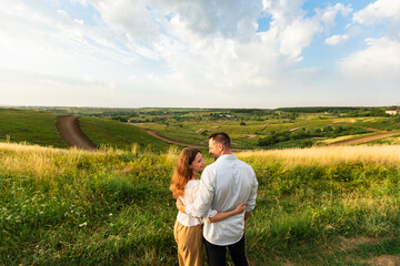 Wall Mural - Young couple enjoying landscape outdoors, rear view