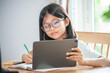 © OHishi_Foto - little girl wearing glasses taking class on line and using tablet for Homeschool Quarantine coranavirus pandemic New normal concept