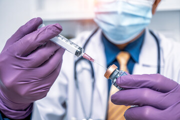 Close up doctor's hand in purple gloves holding medicine bottle flu, coronavirus, covid-19 vaccine disease preparing for human clinical trials vaccination shot, medicine and drug concept.
