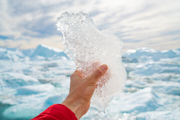 Wall Mural - global warming, climate change and environmental protection concept with icebergs on greenland. hand