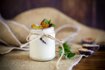 Poster - Homemade sweet yogurt with slices of ripe plums in a glass