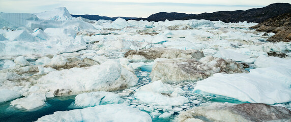 Wall Mural - climate change and global warming - icebergs and from melting glacier in icefjord in ilulissat, gree