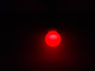 red light bulb in a dark room.