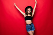 © dianagrytsku - Young woman with hands up win gesture isolated over red background