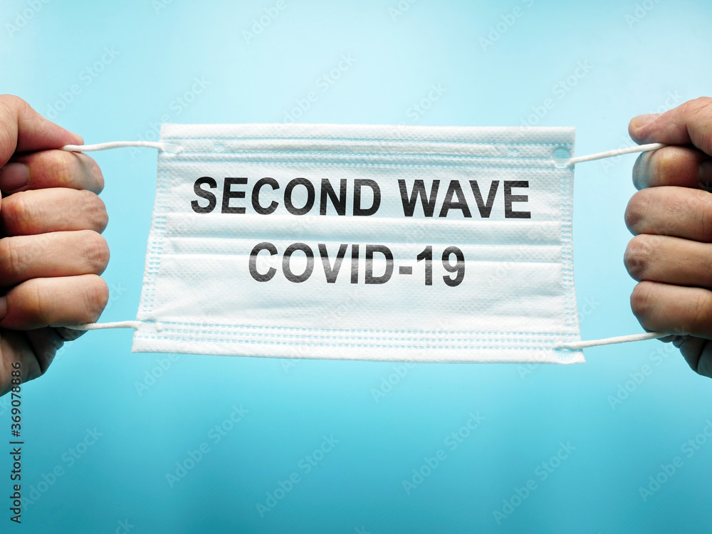 Second wave of covid-19. Hands hold medical mask. - obrazy, fototapety, plakaty 