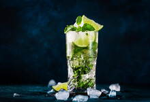 Mojito Cocktail Or Mocktail With Lime, Mint, And Ice In Glass On Blue Background. Summer Cold Alcoholic Non-alcoholic Drink,  Beverage And Cocktail. Copy Space