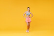 © ViDi Studio - Full length portrait smiling fitness woman in sportswear working out isolated on yellow background. Workout sport motivation lifestyle concept. Mock up copy space. Standing with arms akimbo on waist.