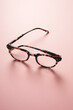 © Natalie JEFFCOTT/Stocksy - Backlit tortoise shell retro style reading glasses on a pink background