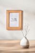 © Maki Company Limited/Stocksy - Still life with vase and photo frames on wooden table over white background