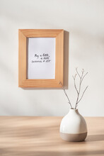Still Life With Vase And Photo Frames On Wooden Table Over White Background