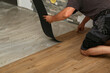 © leomalsam - The worker installing new vinyl tile floor