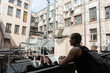 © Milles Studio/Stocksy - Modern man resting on balcony in courtyard of apartment building