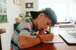 © Maria Manco/Stocksy - boy does schoolwork at home