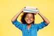 © BONNINSTUDIO/Stocksy - Happy African American girl balancing books on head