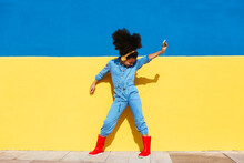 Energetic African American Girl Dancing Against Wall